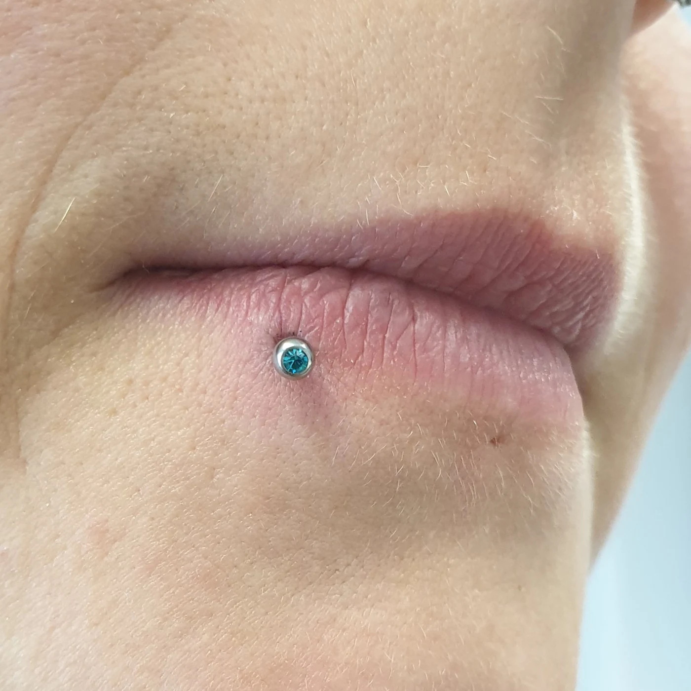 Lippenpiercing mit türkisfarbenem Schmuckstein · Crazy Ink Factory Filderstadt